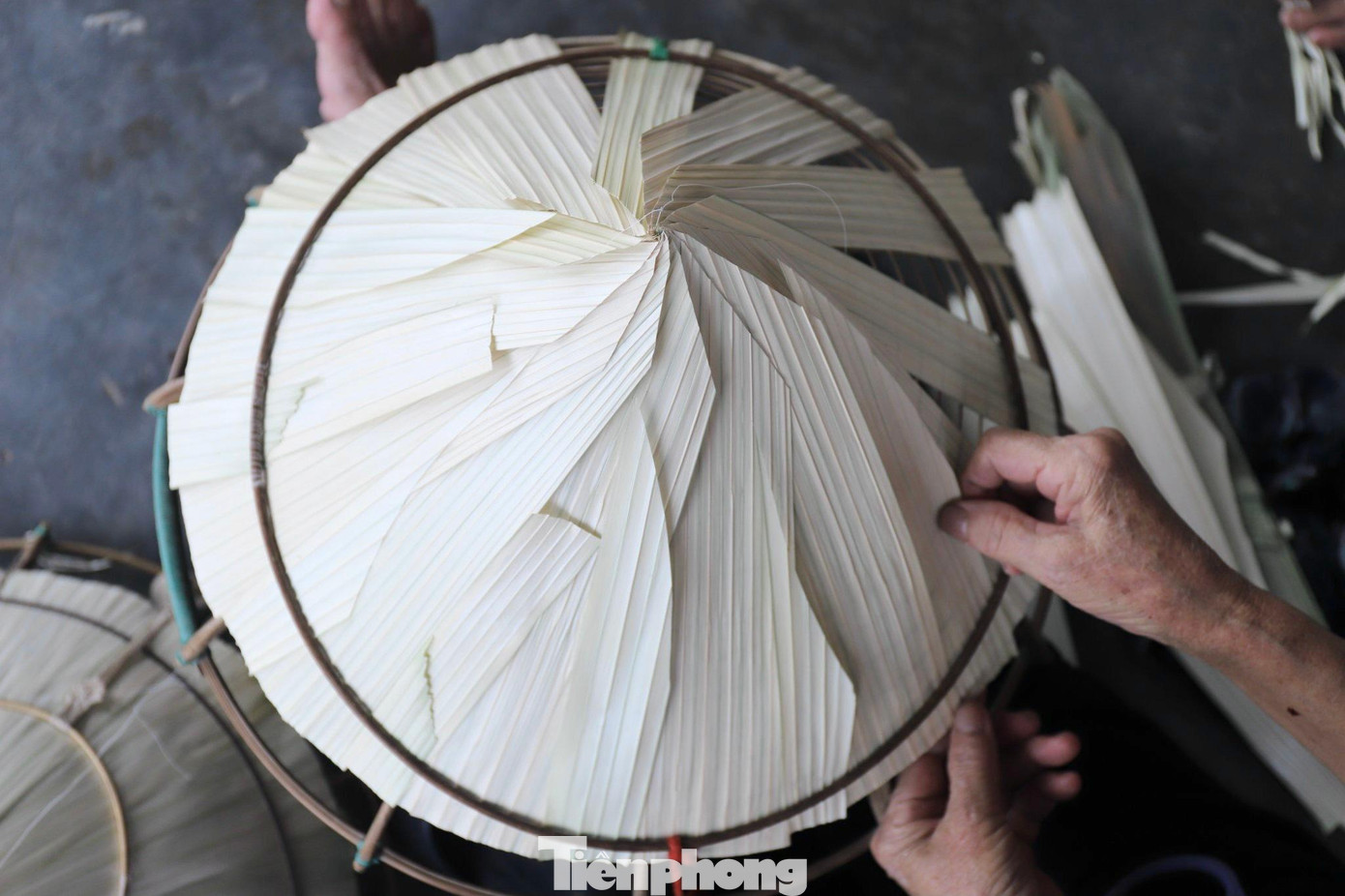 Lá nón sau khi phơi khô sẽ ủi cho thật phẳng, còn tre được vót tròn rồi uốn thành từng vành theo khuôn. Để cố định từng lá nón, người dân sử dụng cước để khâu.