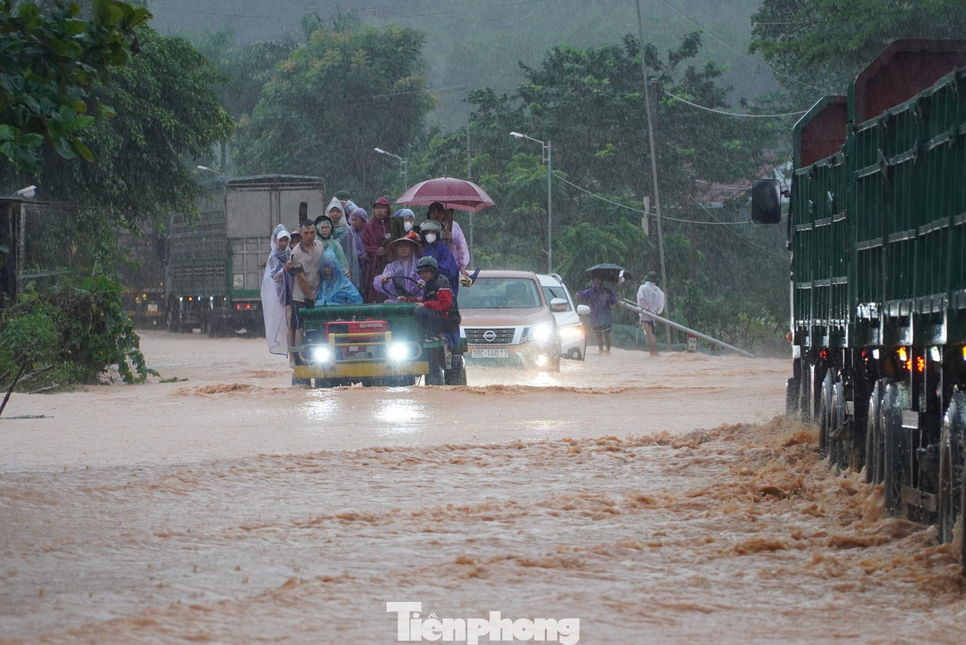 Người dân dùng các xe gầm cao ra hỗ trợ đưa những người dân bị mắc kẹt, không thể di chuyển qua khu vực quốc lộ bị ngập.