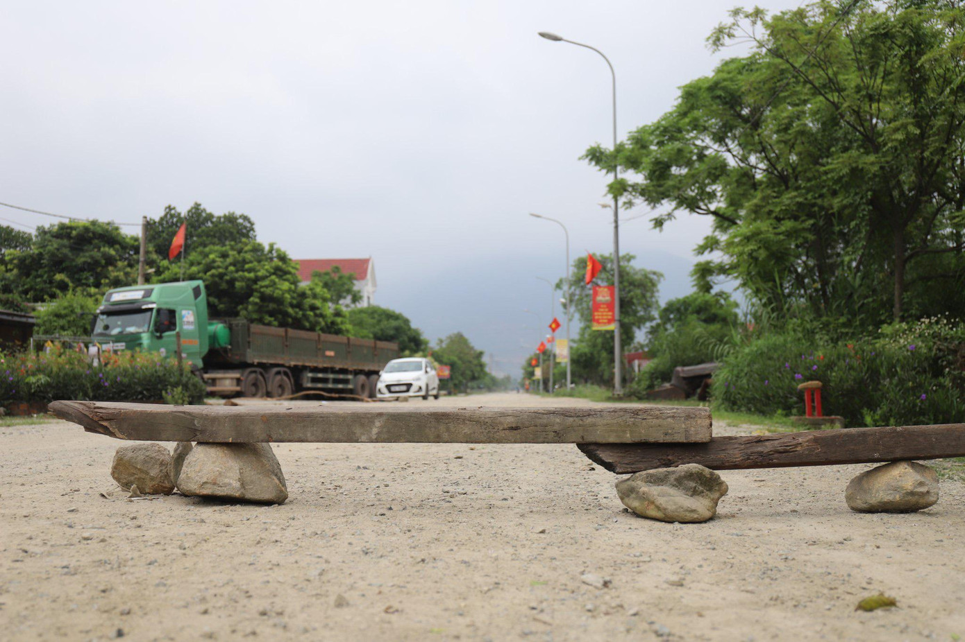 Người dân dùng đá, gỗ chắn ngang đường ngăn xe tải, ô tô chạy nhanh.