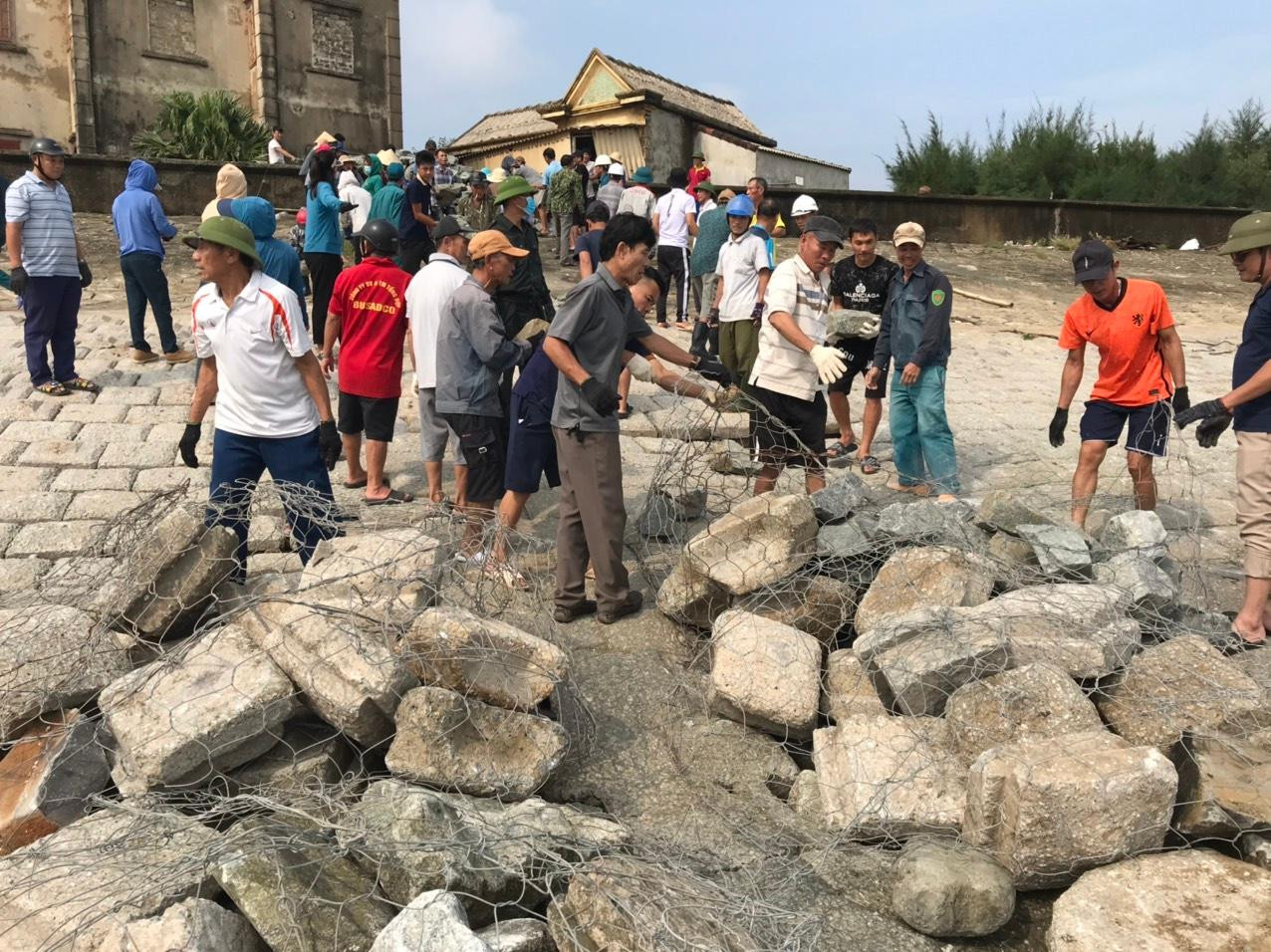 Người dân cùng lực lượng chức năng đã vận chuyển 50m3 đá hộc, xếp vào từng rọ thép để "vá" các điểm sạt lở.