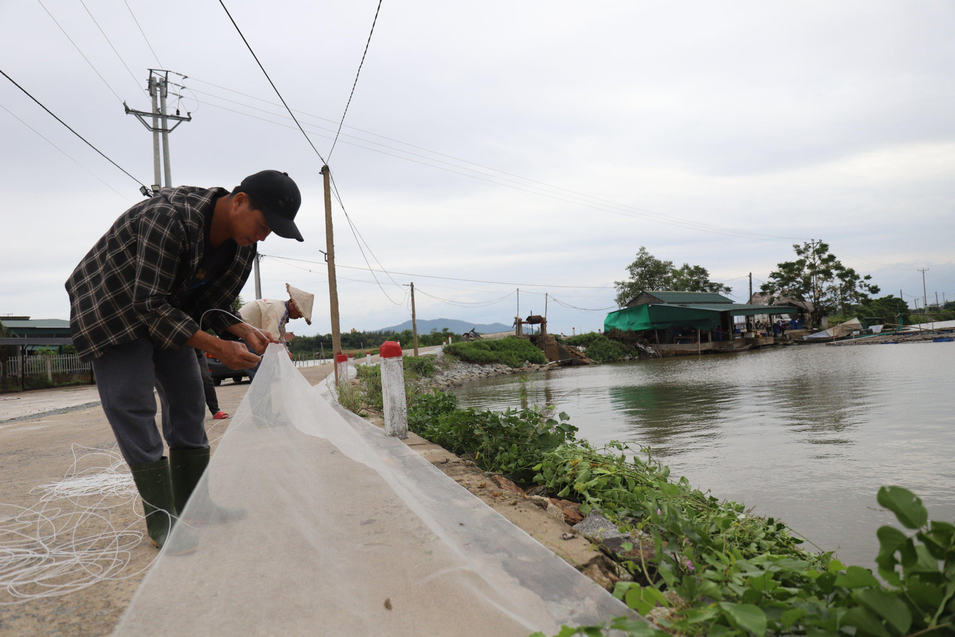 Dân đóng cọc giăng lưới cao 1m toàn bộ ao để giảm thiểu thiệt hại trước diễn biến phức tạp của mưa bão.