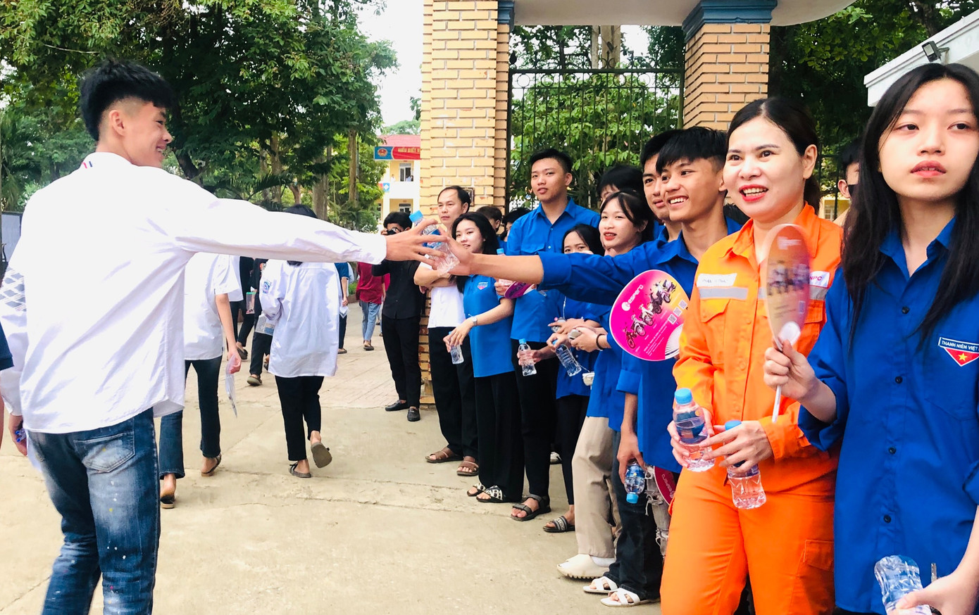 Phía ngoài cổng trường, thanh niên tình nguyện đã có mặt, cầm theo nước, sữa, quạt, bánh ngọt để hỗ trợ các thí sinh sau buổi thi.