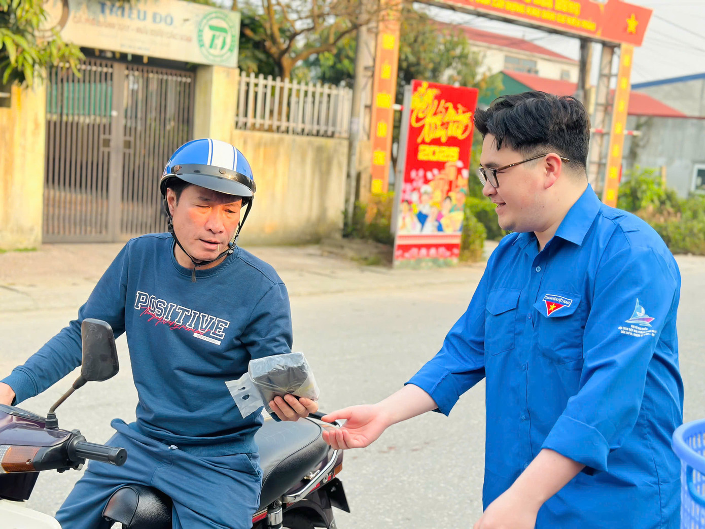 Mô hình thanh niên trao tặng túi đựng rác thải tự phân hủy.