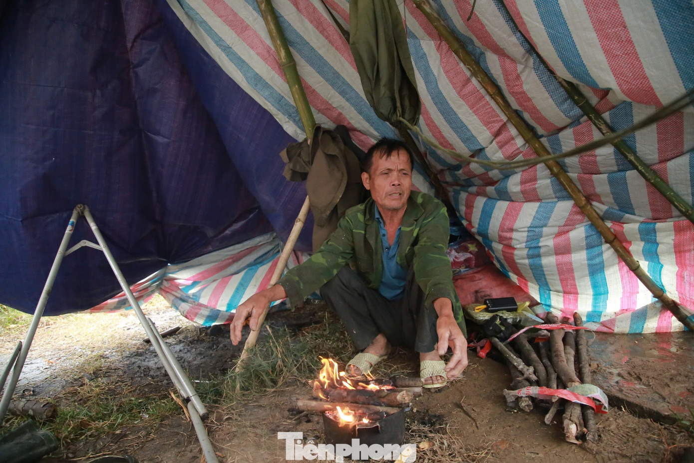 Mưa lớn, gió lạnh, nhiều tiểu thương phải ngồi đốt lửa trong lán nhỏ dựng bên vỉa hè chờ khách đến mua hàng.