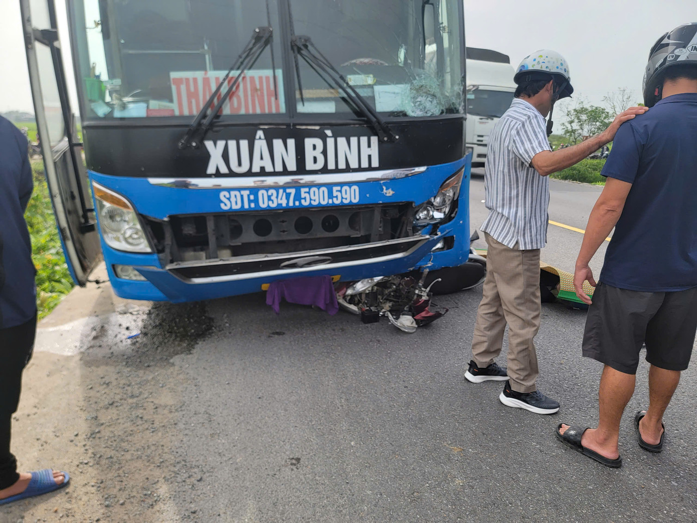 Xe máy bị cuốn vào gầm ô tô.