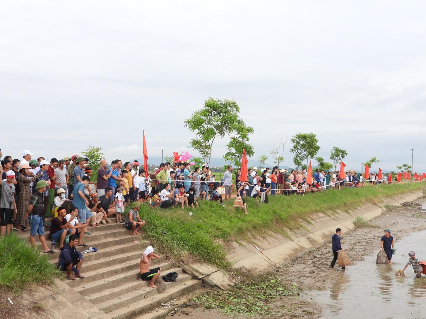 Những "nơm thủ" đánh bắt cá dưới đập, còn phía trên bờ rất nhiều người tham gia đứng cổ vũ, động viên tạo nên không khí hứng khởi cho lễ hội.