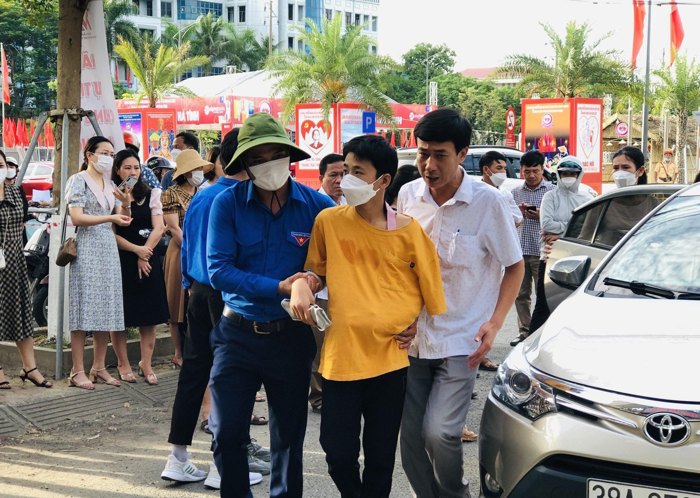 Một thí sinh được các tình nguyện viên hỗ trợ vào phòng thi. Một thí sinh được các tình nguyện viên hỗ trợ vào phòng thi.