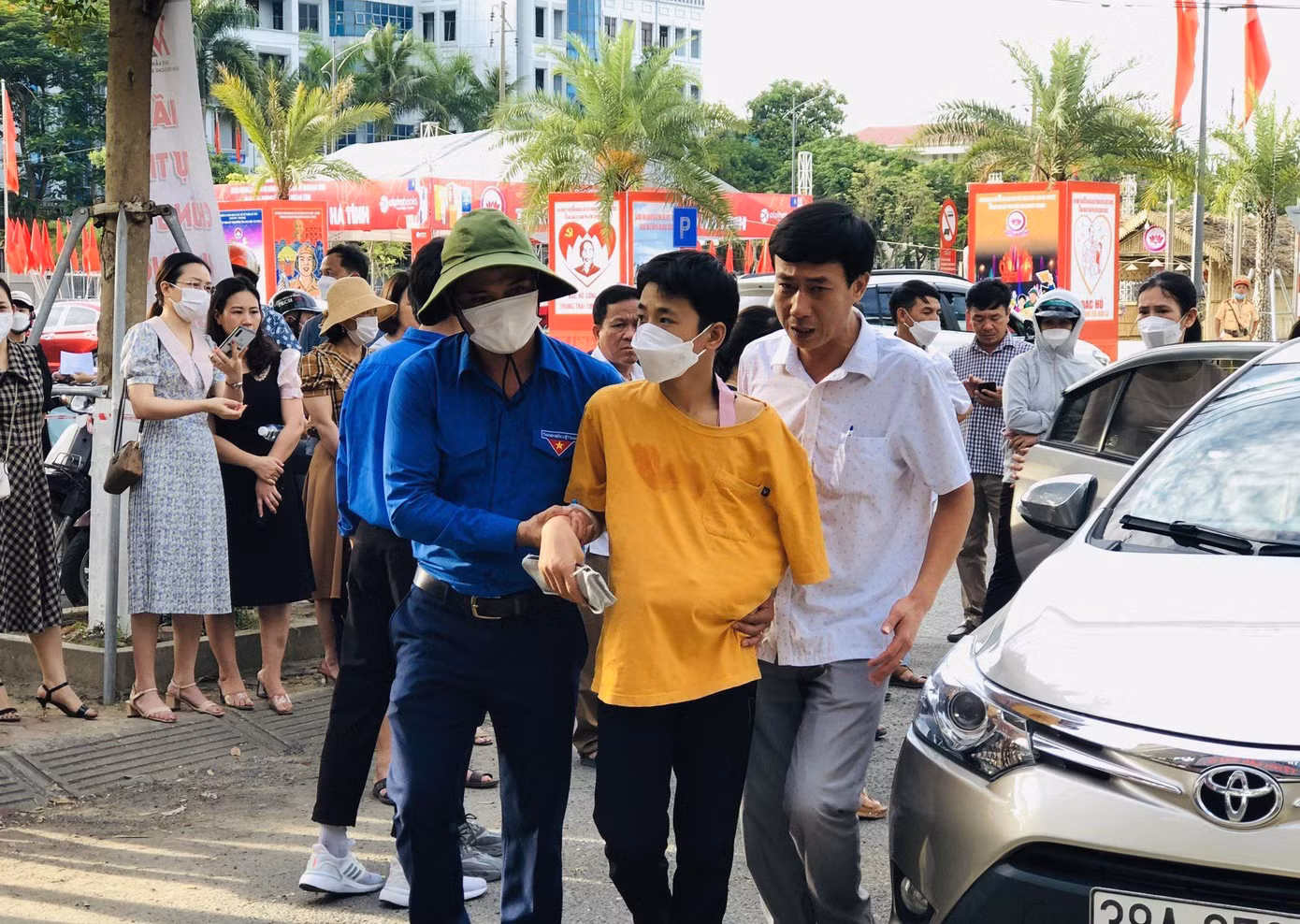 Một thí sinh được các tình nguyện viên hỗ trợ vào phòng thi.