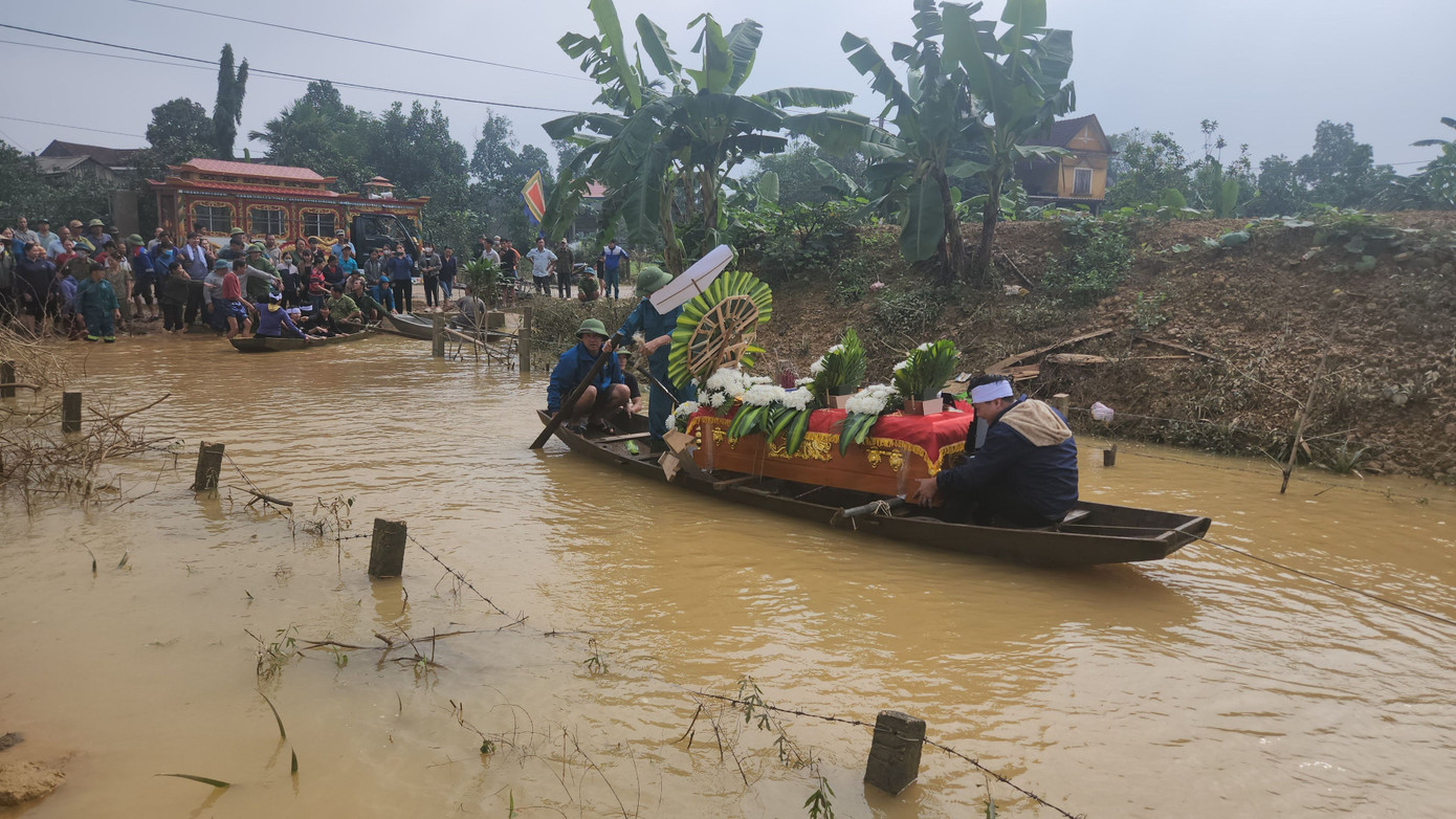 Do đường dẫn ra nghĩa trang đang bị ngập sâu phải dùng 10 chiếc thuyền để chở thi hài và người thân gia đình em D. đi an táng.