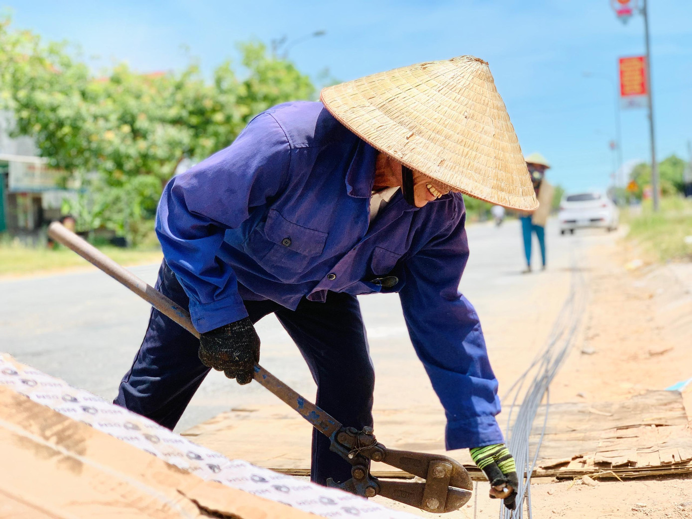 Ông Trương Quang Thanh (xã Thạch Đài, huyện Thạch Hà) đứng giữa đường trong ngày nắng nóng để cắt thép.