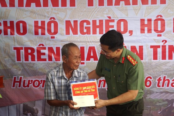 Lãnh đạo Công an tỉnh Hà Tĩnh tặng quà chúc mừng hộ gia đình có ngôi nhà mới.