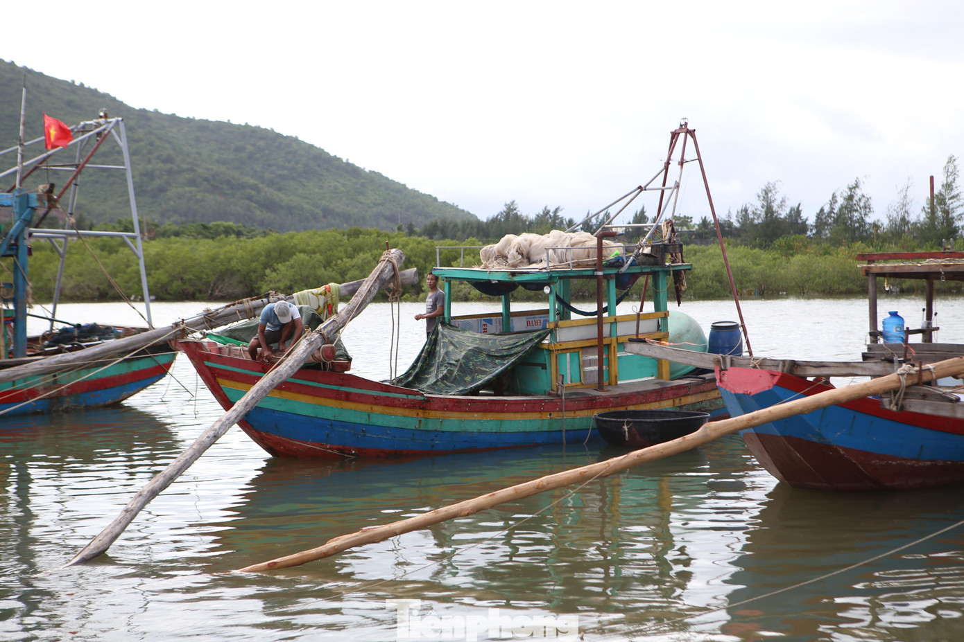Ngư dân căng bạt để bảo vệ phần máy, tránh nước ngập vào thuyền.
