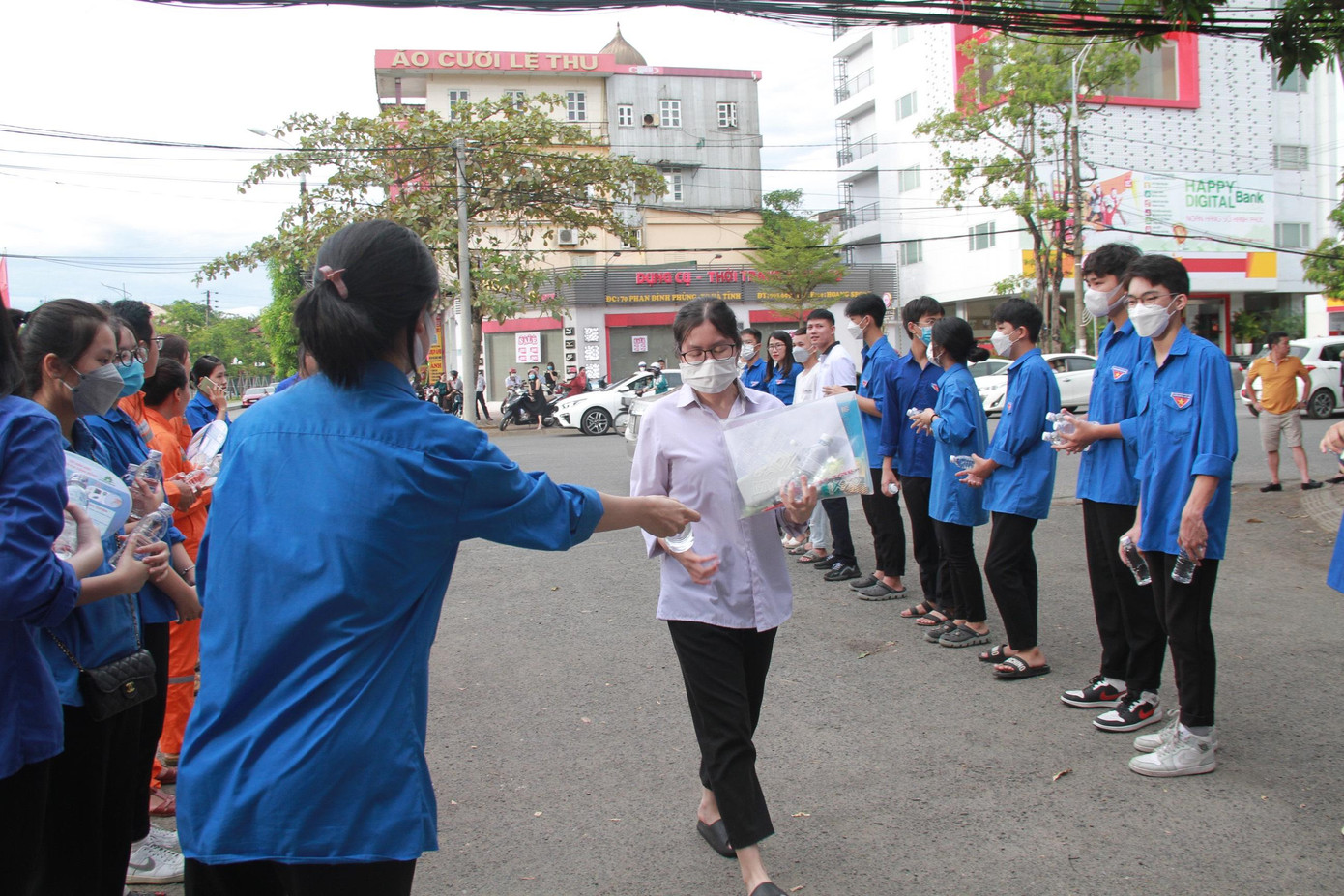 Các tình nguyện viên đưa nước cho thí sinh khi vào phòng thi và kèm theo lời chúc tự tin, làm bài tốt.