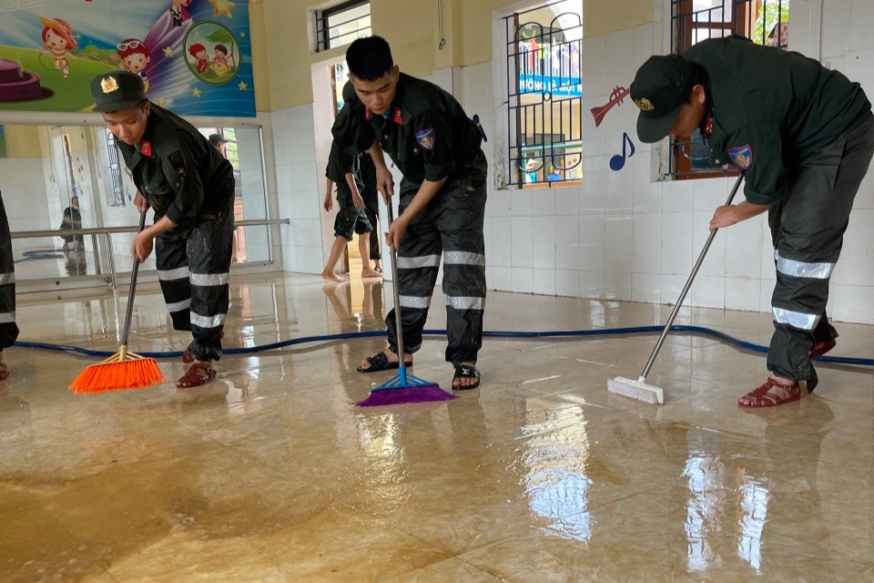 Tại Hà Tĩnh sáng nay trời hửng nắng, nước rút gần hết ở trong nhà và các công sở, để lại các lớp bùn non trên tường và mặt đất. Trong ảnh lực lượng CSCĐ đã dọn rửa lại phần nền nhà để đón trẻ trở lại trường sau lũ.