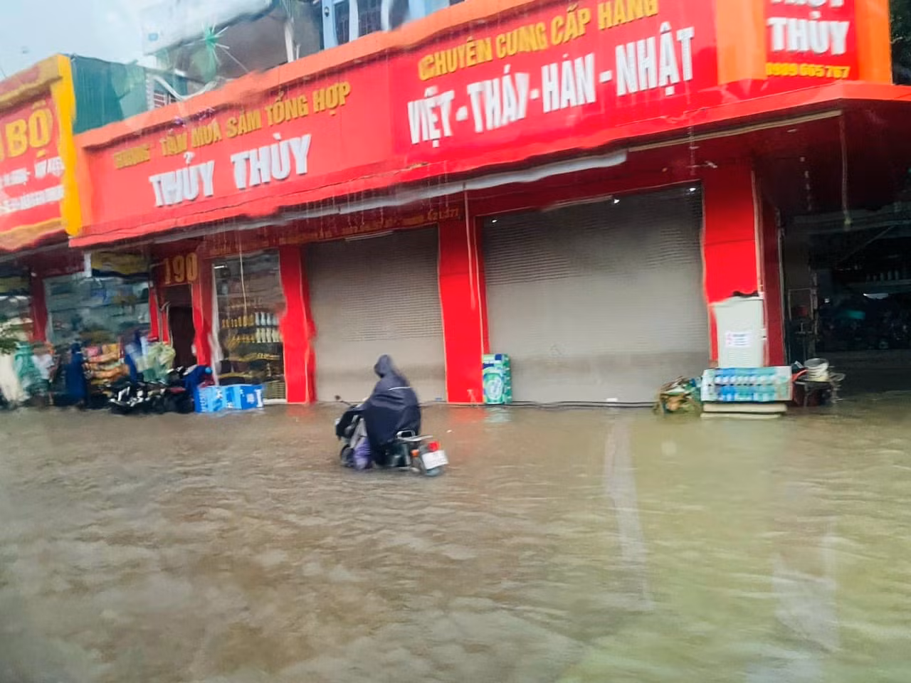 Nhiều phương tiện nước ngập gần hết bánh xe, cửa hàng phải đóng cửa.