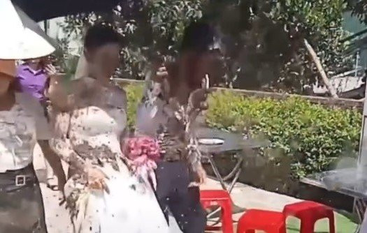 Hình ảnh cô dâu và chú rể bị tạt chất bẩn gây xôn xao. (Ảnh cắt từ clip) Hình ảnh cô dâu và chú rể bị tạt chất bẩn gây xôn xao. (Ảnh cắt từ clip)