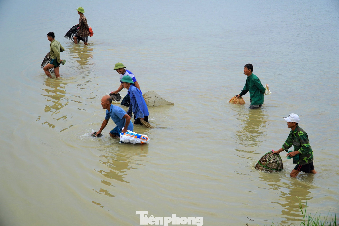 Người tay cầm nơm, tay cầm bao tải mang theo để bắt và đựng cá.