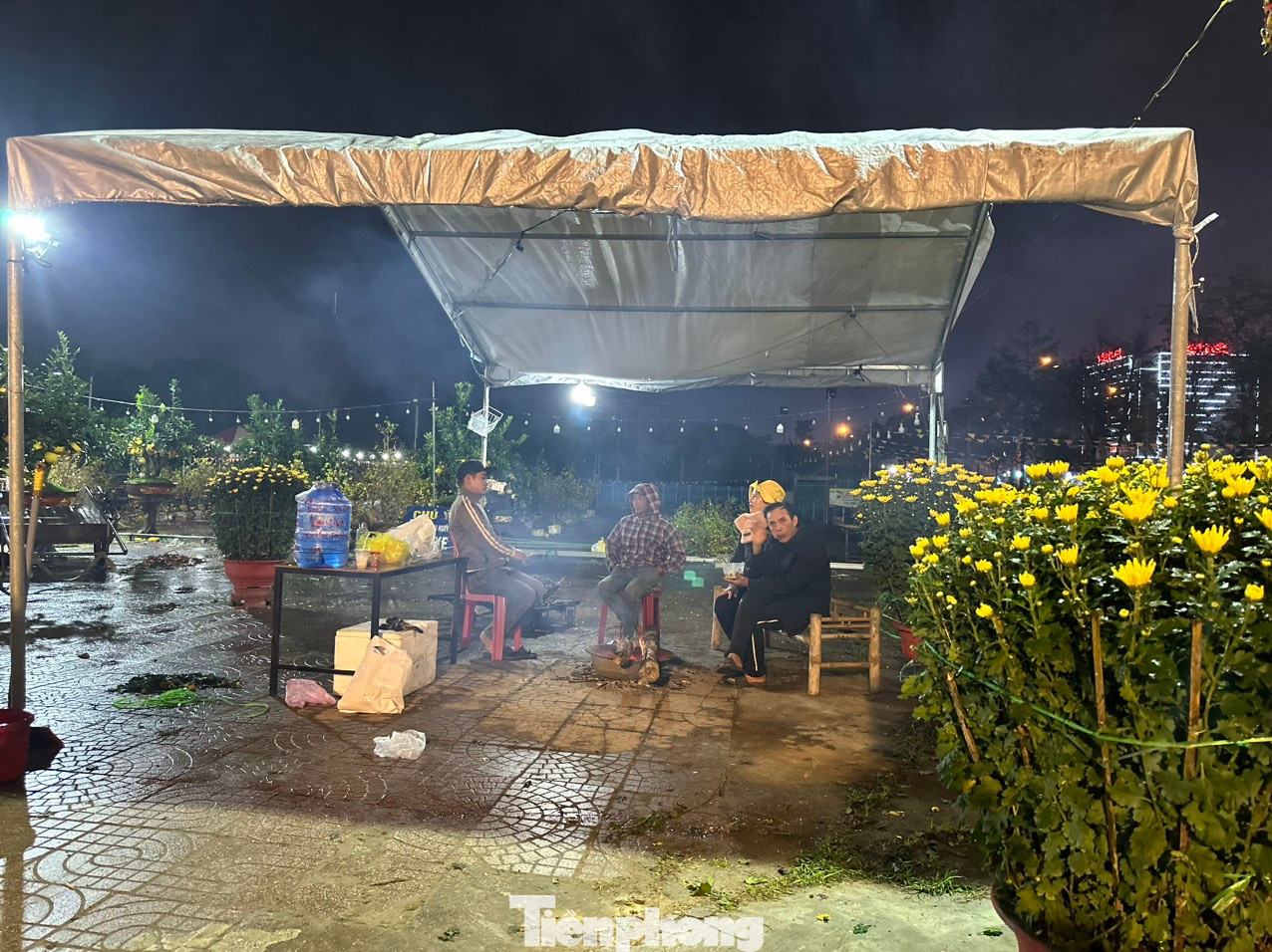 Dù thời tiết có mưa, nhiệt độ giảm, nhưng những tiểu thương vẫn phải co ro trong đêm để bán hoa.