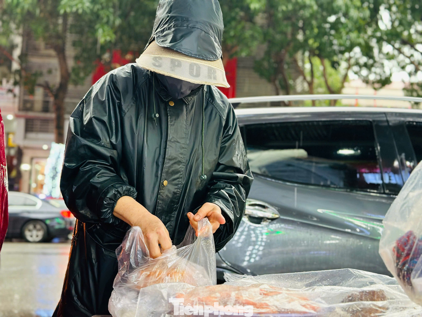 Người dân "đội mưa" đi mua xôi về cúng ngày vía Thần tài.