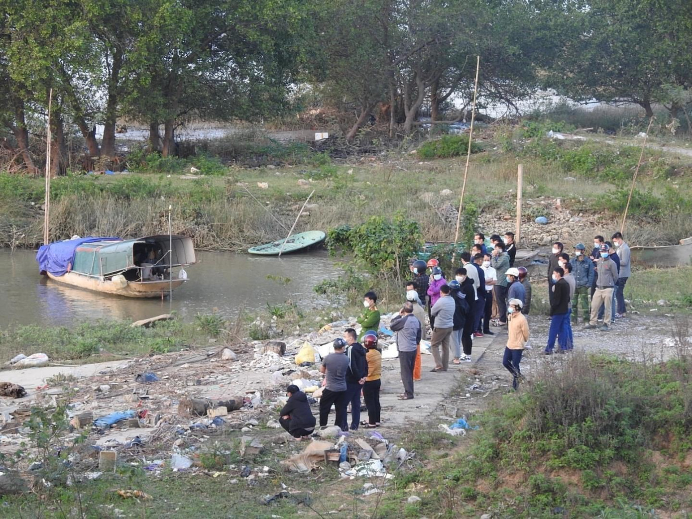 Người thân cùng chính quyền địa phương có mặt tại bờ sông để tổ chức tìm kiếm thi thể nạn nhân.