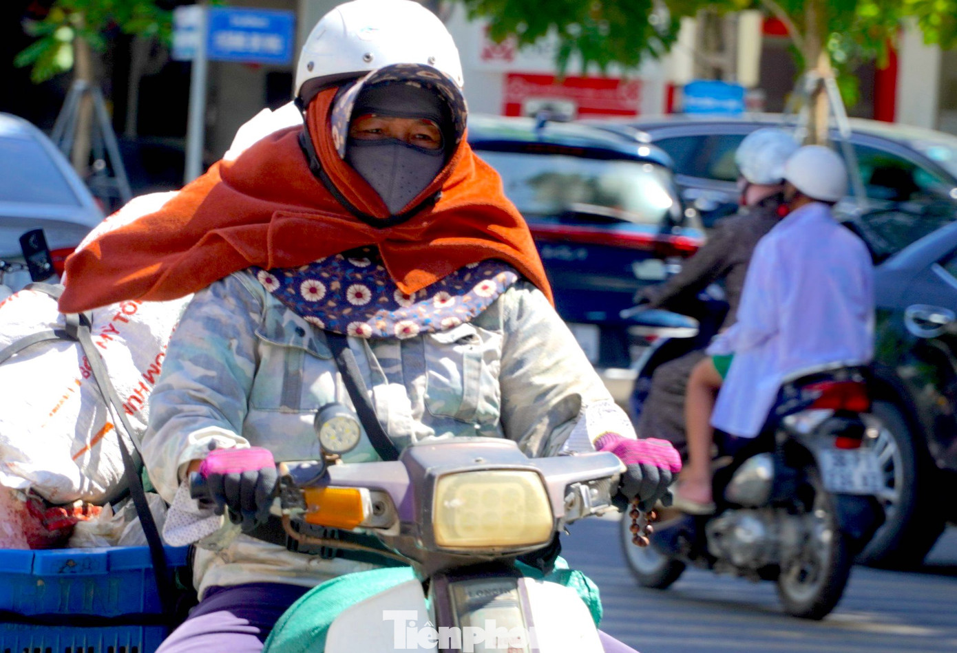 Dưới ánh nắng chói chang, người phụ nữ khoác áo dài tay, đeo bao tay, nhiều lớp khẩu trang để che chắn khỏi tác động của tia cực tím khi nắng nóng kéo dài.