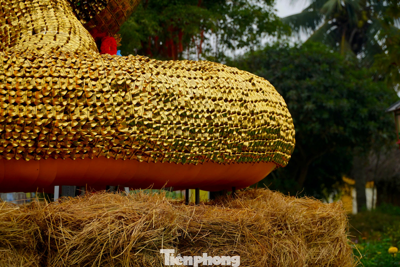 Phần thân được tạo hình, lắp ghép từ hàng chục nghìn miếng nhựa màu vàng nhỏ cuộn tròn tạo thành vảy rắn.