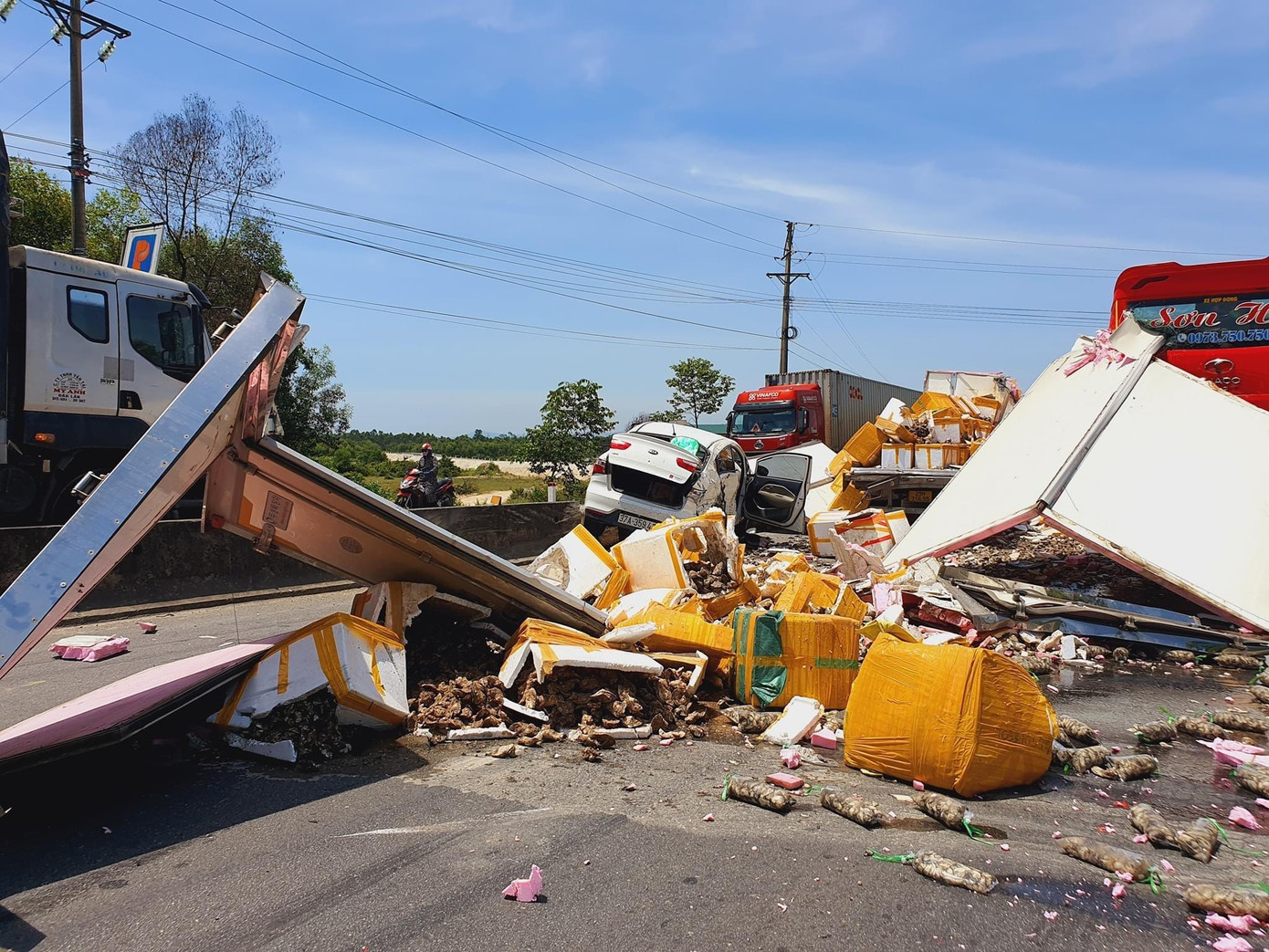 Hàng hoá trên xe đông lạnh bị đổ xuống đường. Hàng hoá trên xe đông lạnh bị đổ xuống đường.
