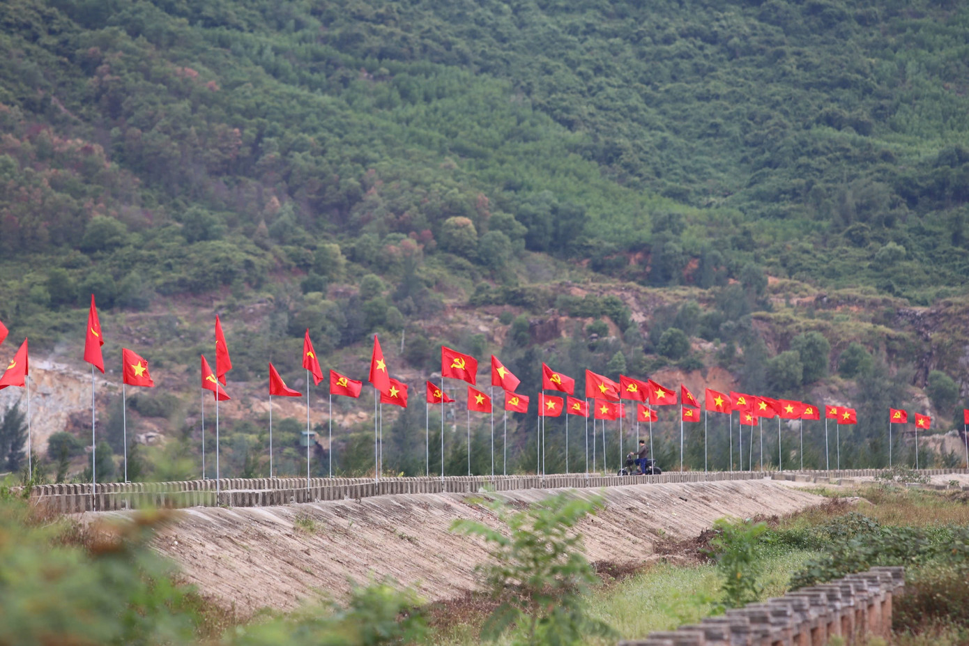 Những lá cờ nhuộm đỏ con đê vùng biển.