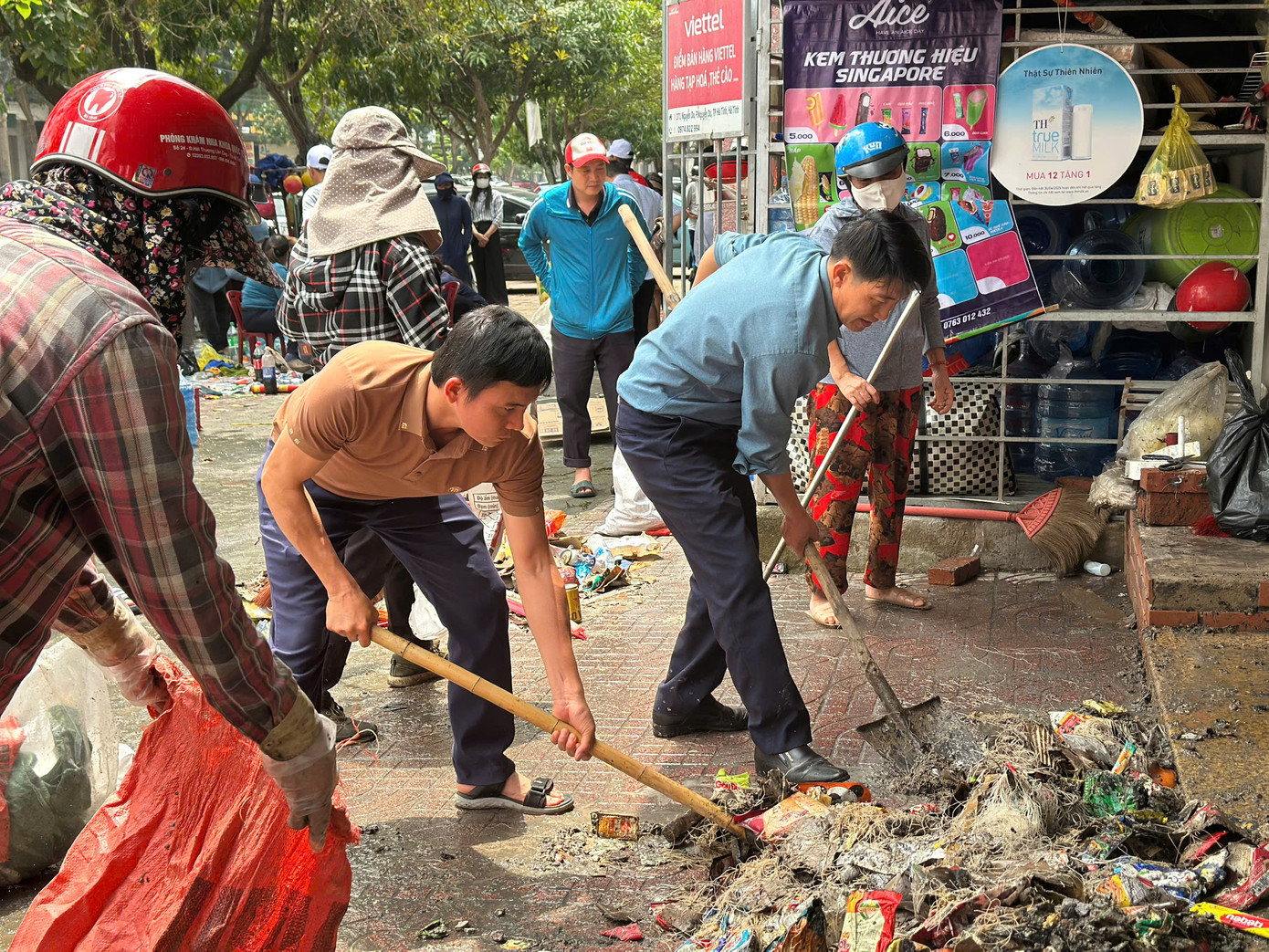 Nhiều người hỗ trợ chủ cửa hàng thu gom đồ đạc, dọn dẹp sau đám cháy.