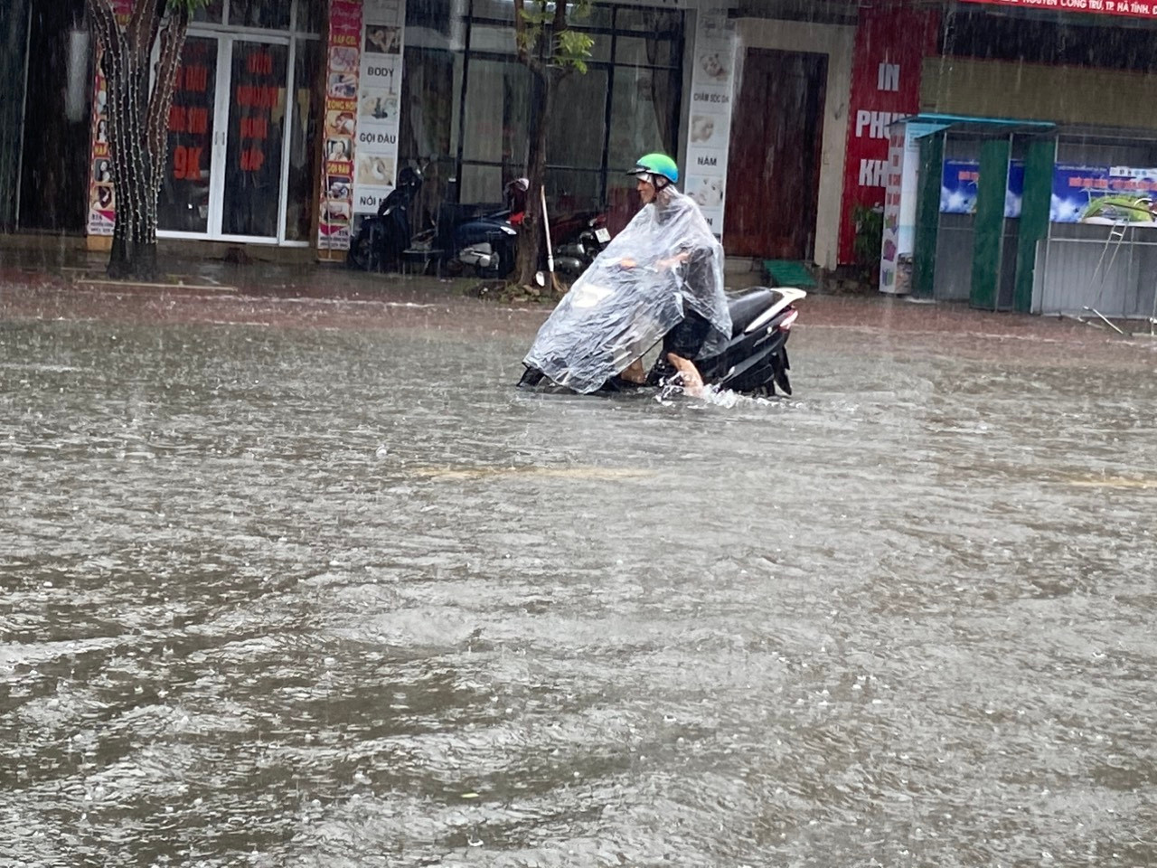Tại khu vực đường Nguyễn Công Trứ đã “biến thành sông” sau trận mưa lớn kéo dài. Nhiều gia đình sống bên đường phải dùng các đồ vật để ngăn nước tràn vào nhà.