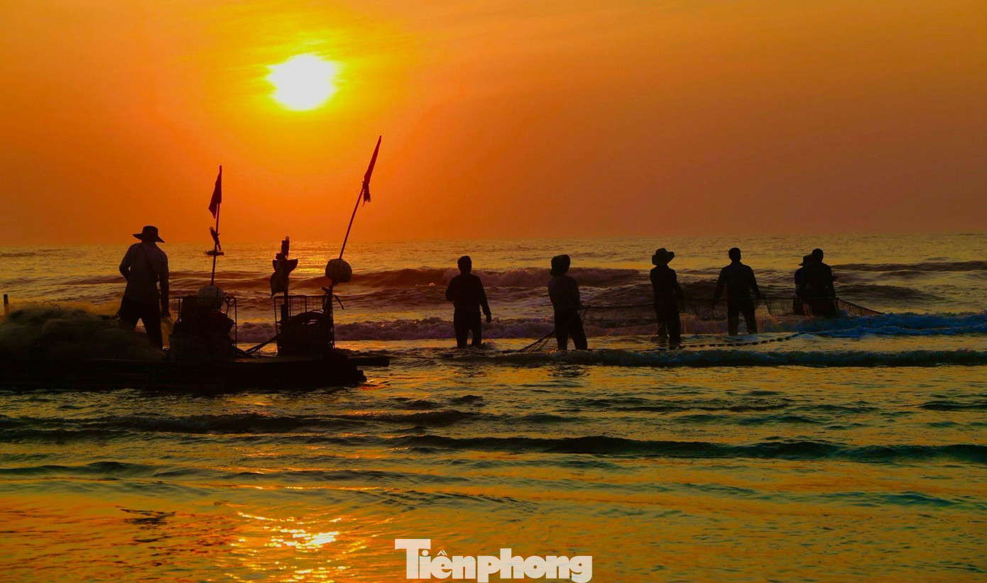 Khoảng 5h sáng, ánh bình minh đã trải dài trên biển huyện Nghi Xuân (Hà Tĩnh). Thời điểm này cũng là lúc ngư dân vùng biển đang thu lưới mang theo cá, tôm vào bờ.