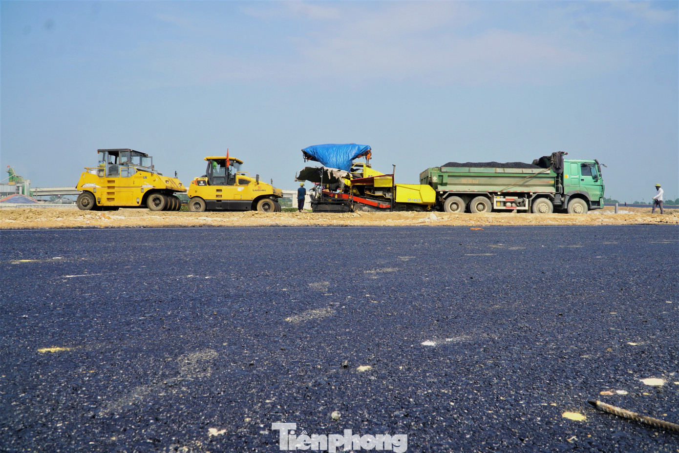 Những thảm lớp bê tông nhựa cuối cùng đang được công nhân hoàn thiện.