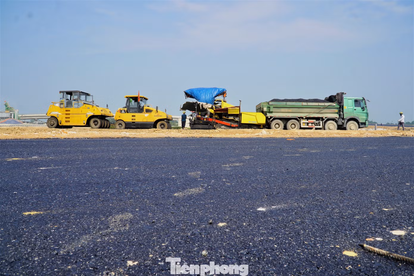 Những thảm lớp bê tông nhựa cuối cùng đang được công nhân hoàn thiện.