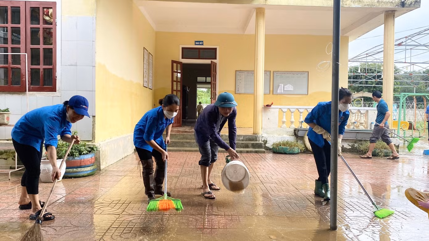 Áo xanh tình nguyện cùng quét dọn lại sân trường.