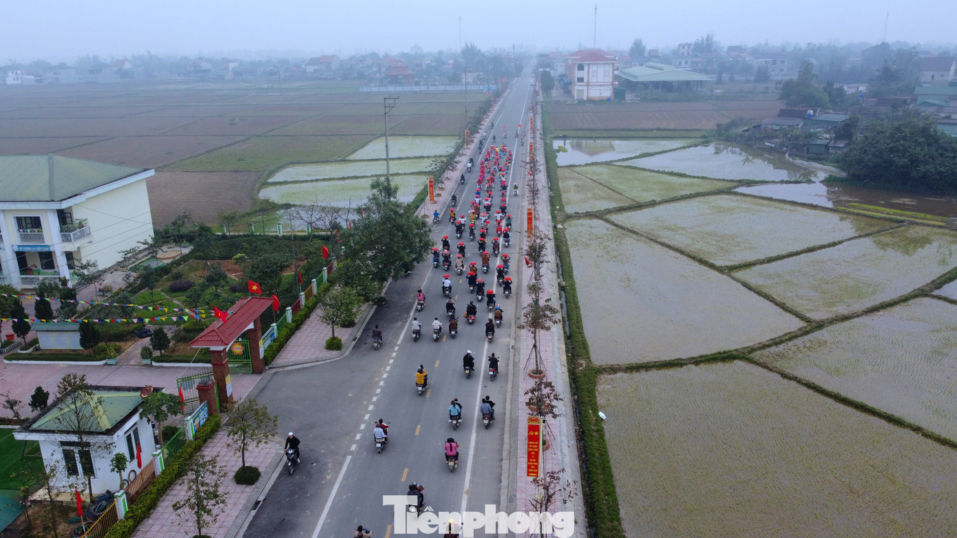 Trong ảnh hàng trăm người di chuyển, đội lễ từ đường làng đến đền vua Mai.