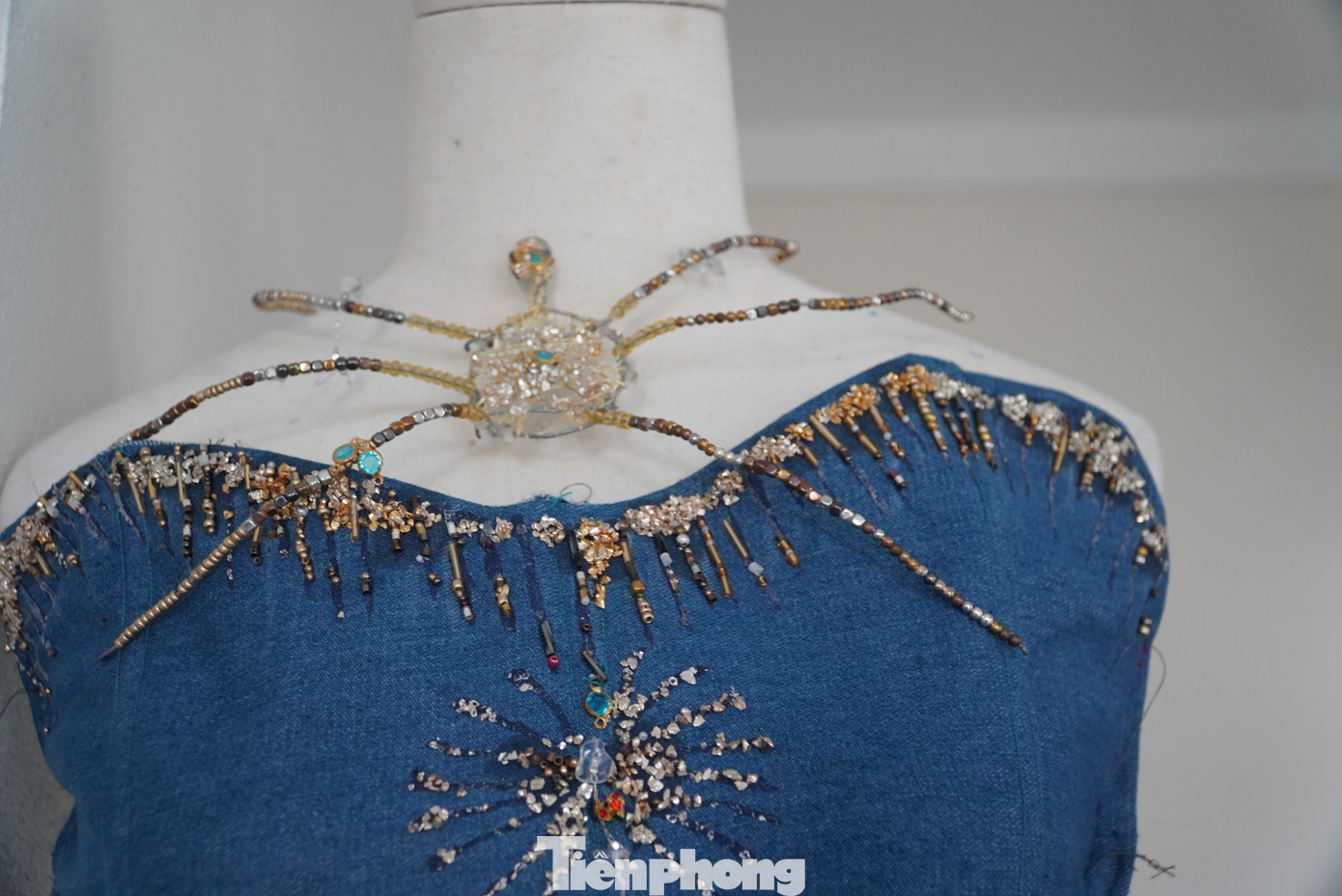 Trong ảnh là tác phẩm “khơi” được lấy cảm hứng từ những đợt sóng biển đầy du dương; ánh mặt trời ở phần thân áo được đính kết tỉ mỉ, vắt ngang thân váy tạo nên sự mềm mại.