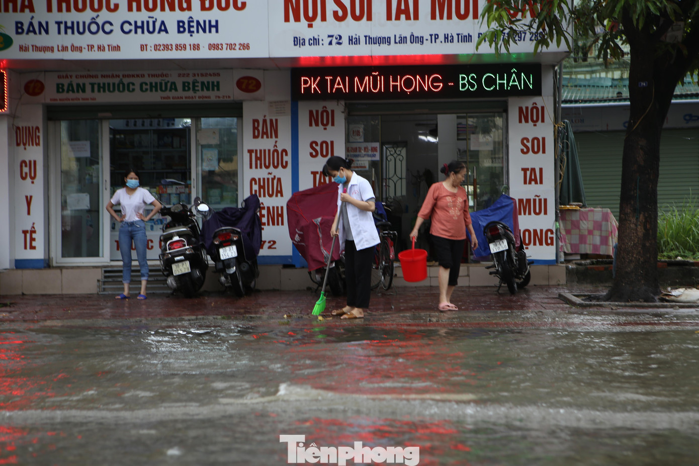 Nhiều người dân ở đường Hải Thượng Lãn Ông thu dọn nhà, vỉa hè sau khi nước ngập đường.