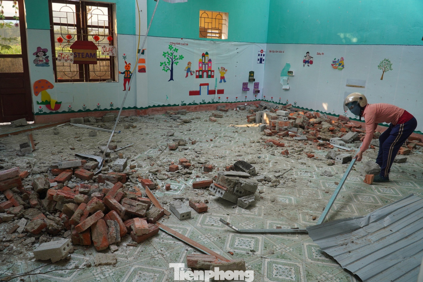 Nhiều phần tường bị đổ xuống sàn lớp học. May mắn thời điểm lốc xoáy học sinh, giáo viên chưa tới lớp. Trong ảnh nữ giáo viên đang dọn dẹp mái tôn, gạch vỡ giữa nền nhà. Nhiều phần tường bị đổ xuống sàn lớp học. May mắn thời điểm lốc xoáy học sinh, giáo viên chưa tới lớp. Trong ảnh nữ giáo viên đang dọn dẹp mái tôn, gạch vỡ giữa nền nhà.