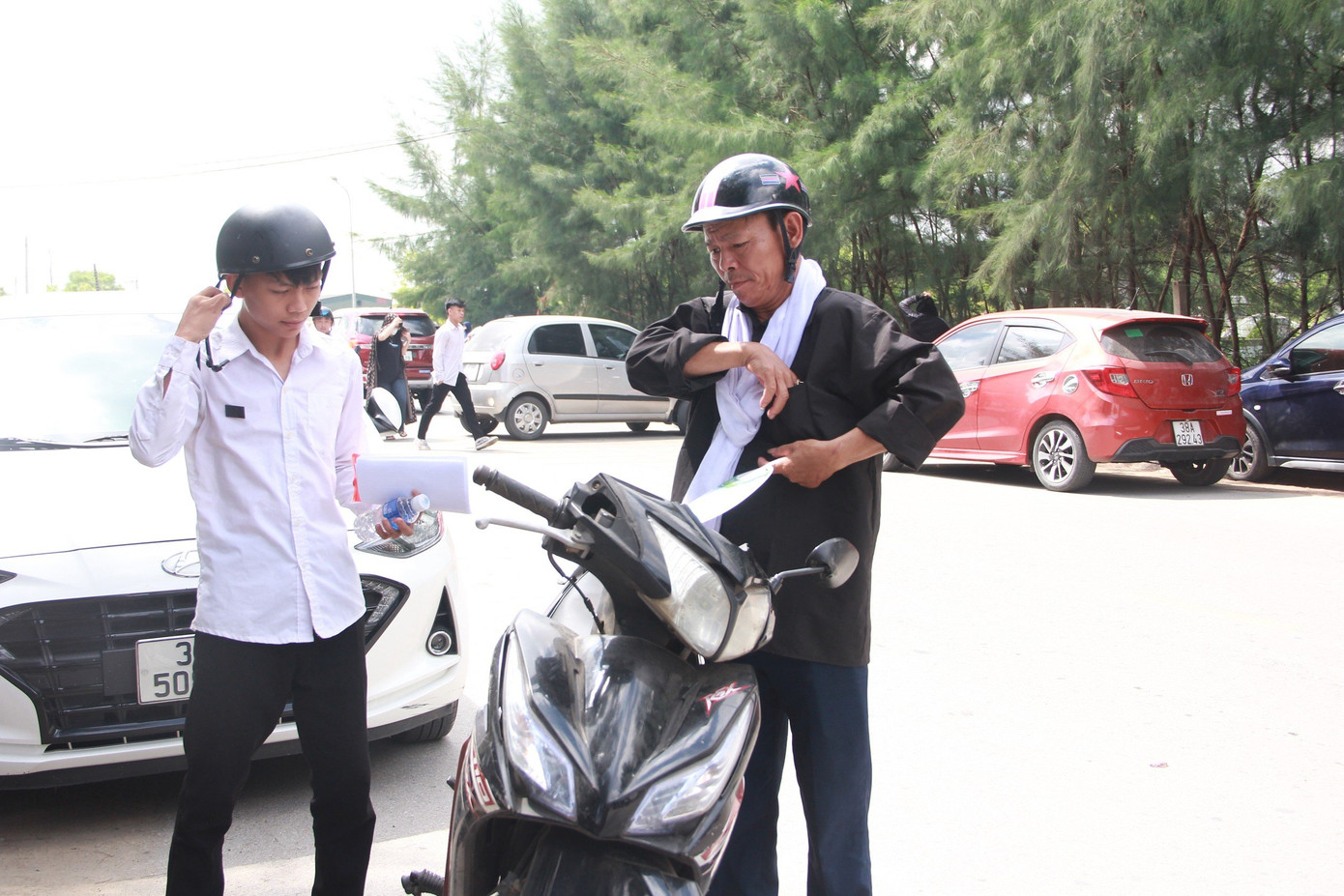 Ông Dụng chở con trai đến điểm thi. Ông Dụng chở con trai đến điểm thi.