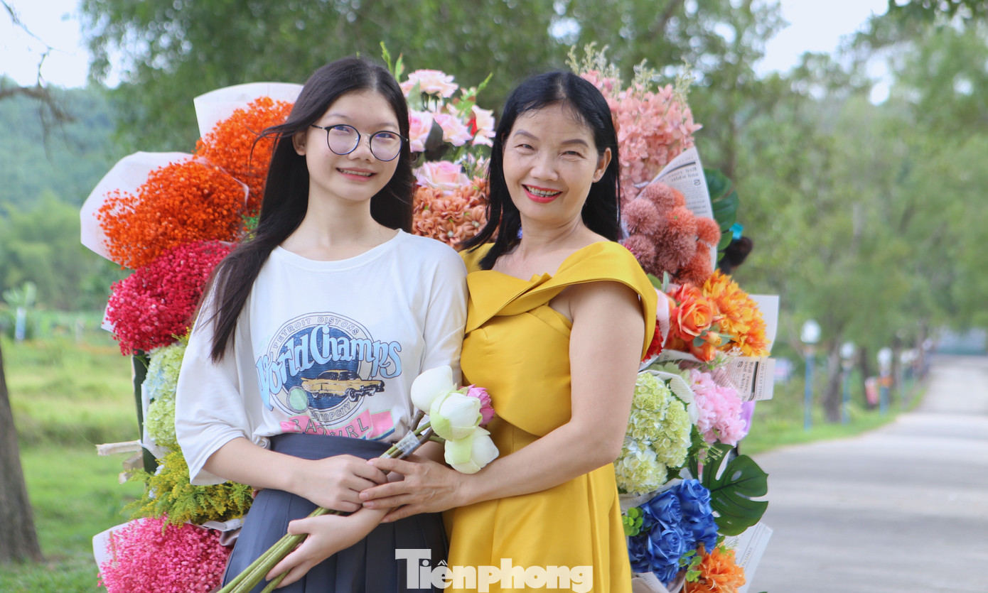 Mẹ con cùng tạo dáng bên xe chở hoa.