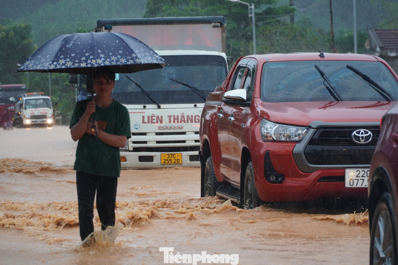 Tại đây, dòng nước chảy cuồn cuộn trên quốc lộ. Là tuyến đường huyết mạch, phương tiện giao thông qua lại đông đúc nên di chuyển qua khu vực ngập gặp nhiều khó khăn.