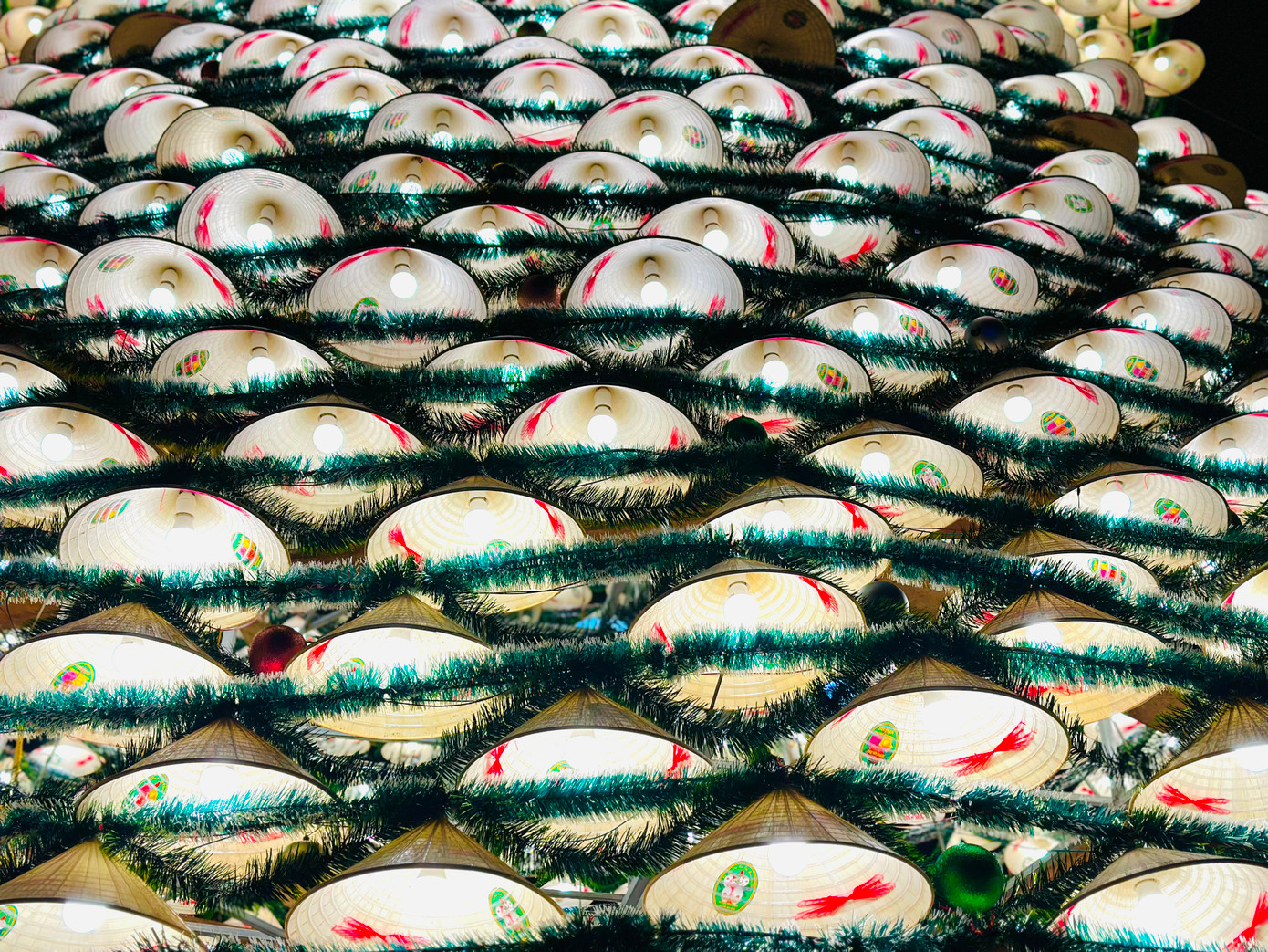 Những chiếc nón lá được xếp đặt khéo léo xung quanh bộ khung sắt nặng hàng tấn tạo thành hình cây thông Noel 3 tầng lung linh.