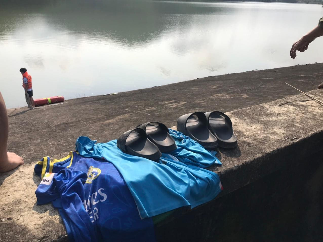 Dép và quần áo hai nạn nhân bỏ lại trên bờ. Dép và quần áo hai nạn nhân bỏ lại trên bờ.