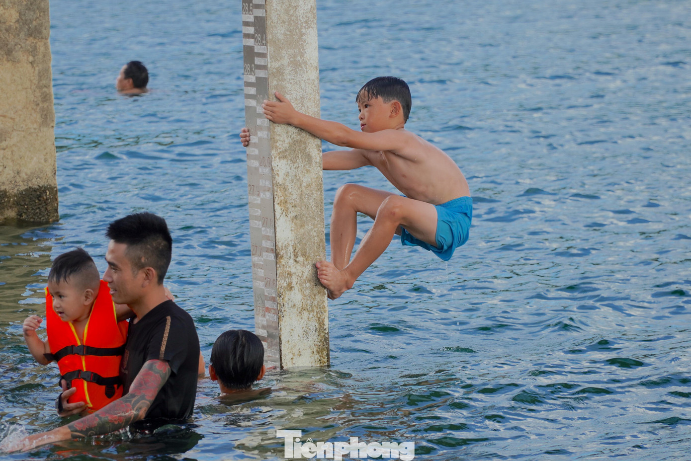 Tại điểm tắm dưới khu nhà điều tiết nước hồ Kẻ Gỗ, những em nhỏ còn trèo lên cột để nhào lộn, thử cảm giác mạnh.