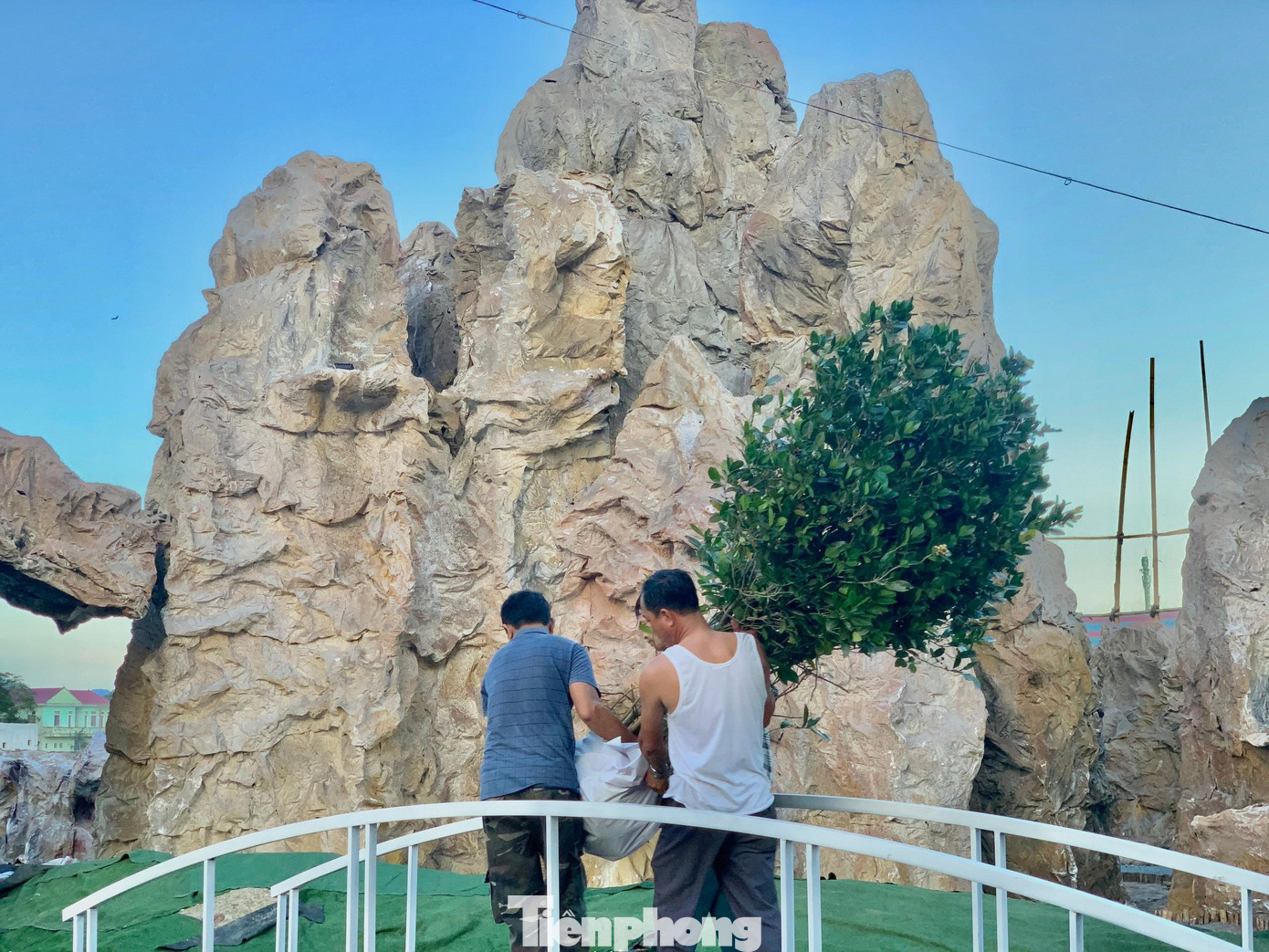 Phía dưới hang đá được làm các tiểu cảnh như hồ nước thả cá, cây, cỏ được trồng giống như thật. Trong ảnh người dân đang đưa các cây cảnh vào để trồng bên trong hang đá. Phía dưới hang đá được làm các tiểu cảnh như hồ nước thả cá, cây, cỏ được trồng giống như thật. Trong ảnh người dân đang đưa các cây cảnh vào để trồng bên trong hang đá.