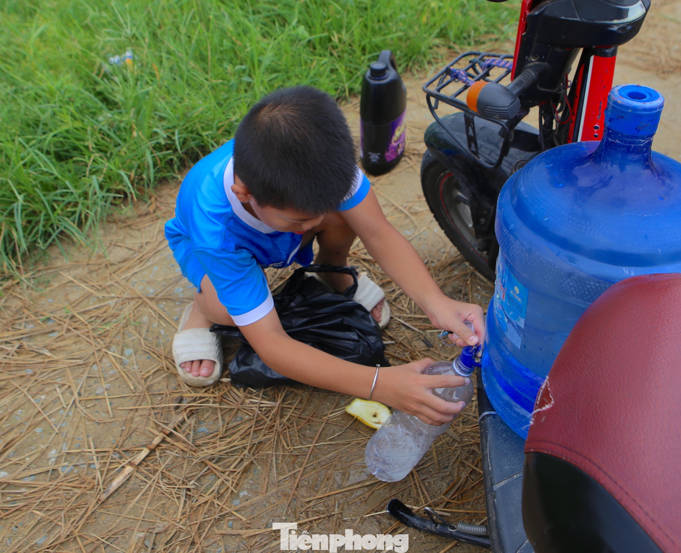 Không chỉ người lớn mà nhiều em nhỏ cũng chở cả can nước ra đồng bắt dế vào mùa này.