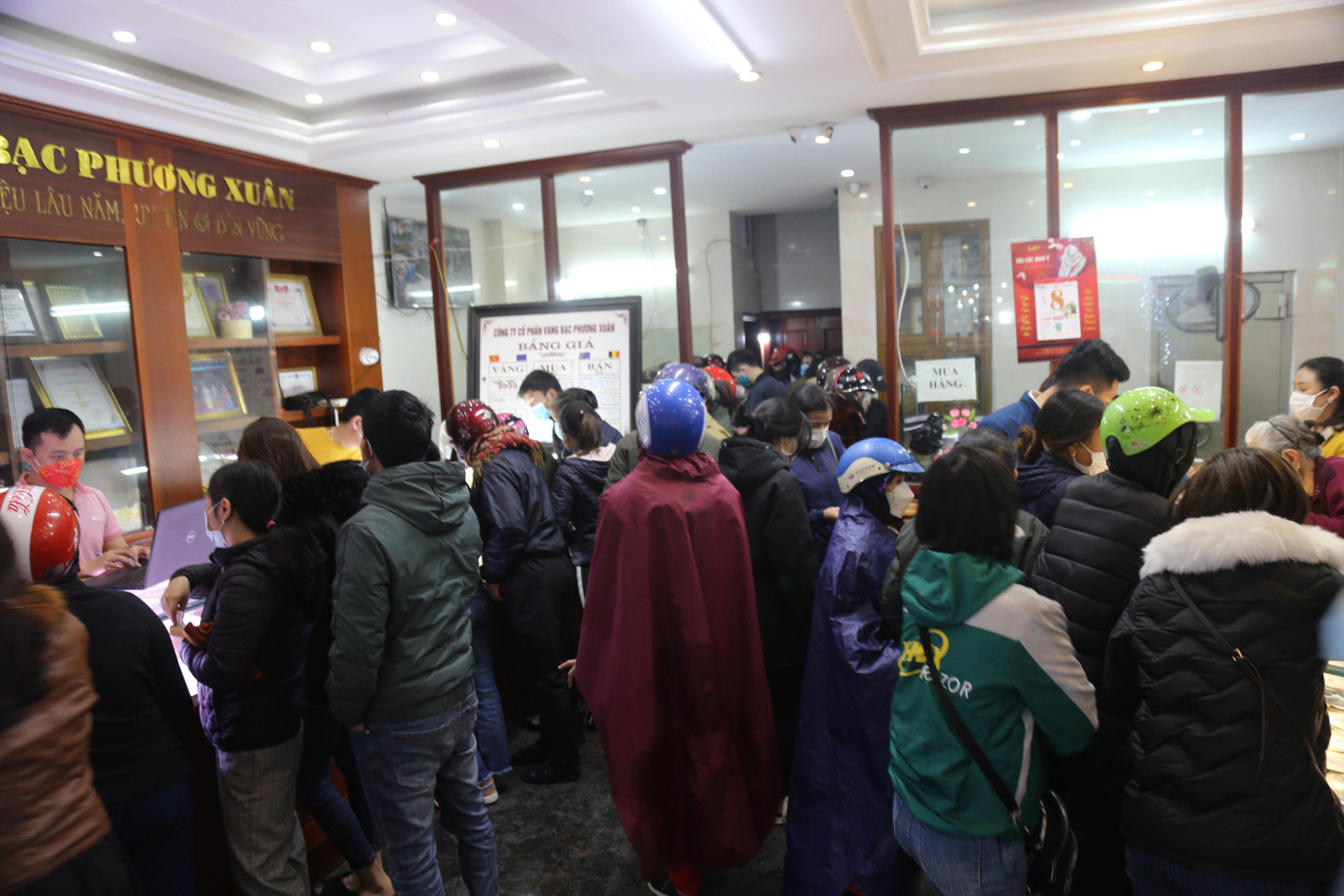 Tại tiệm vàng Phương Xuân, 9h30 do thời tiết mưa lạnh, nhiều người dân mang cả áo mưa chen chúc, chờ tới lượt để mua vàng.;