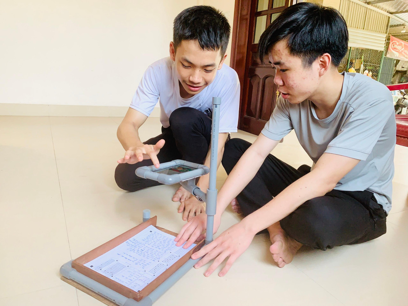 Mậu Đức cùng Huy Hoàng thực hiện chấm thi trắc nghiệm trên sáng chế mà nhóm thực hiện.