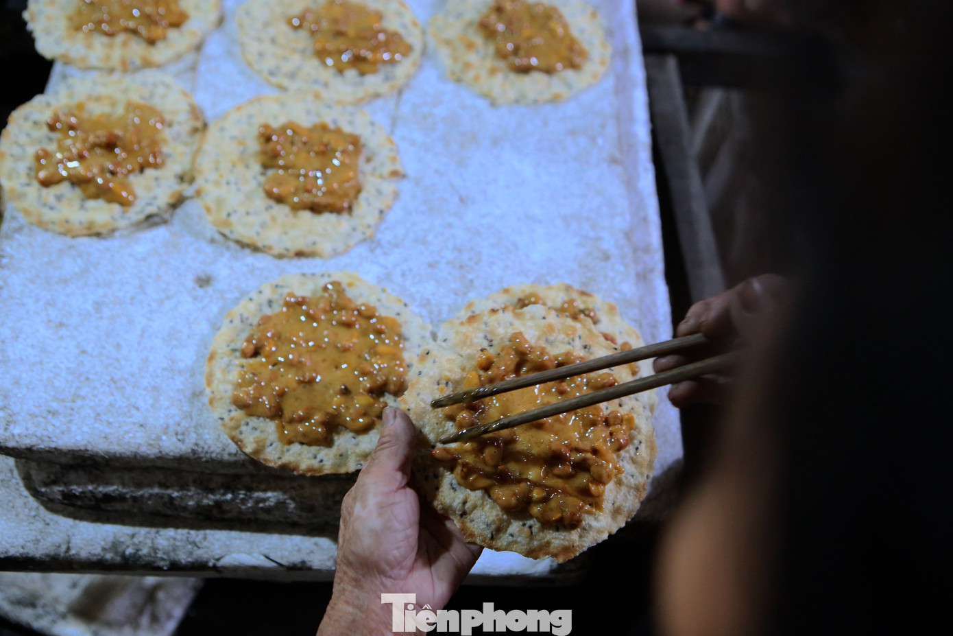 Trước đây, kẹo nấu xong sẽ đổ lên lá chuối hoặc giấy. Khi ăn, người ta sẽ lấy một ít nước bôi lên mặt sau để bóc lớp lót. Về sau, người ta thay thế lớp lót ấy bằng bánh đa vừng. Cách làm này tạo thêm rất nhiều hương vị cho kẹo bởi độ giòn của bánh đa nướng và độ thơm của vừng.