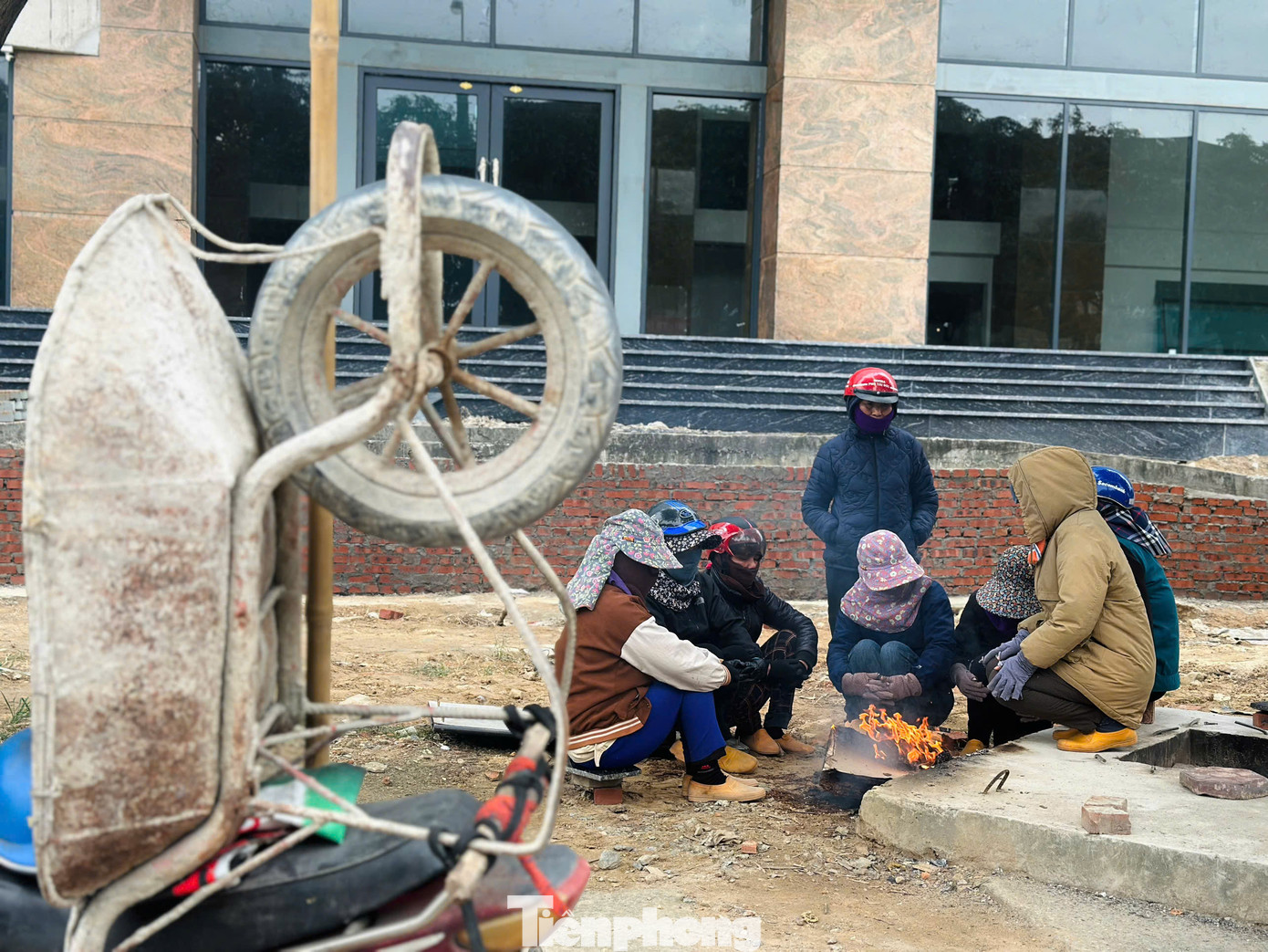 Những lao động tự do đốt lửa ngồi bên vỉa hè chờ việc ngày cuối năm.